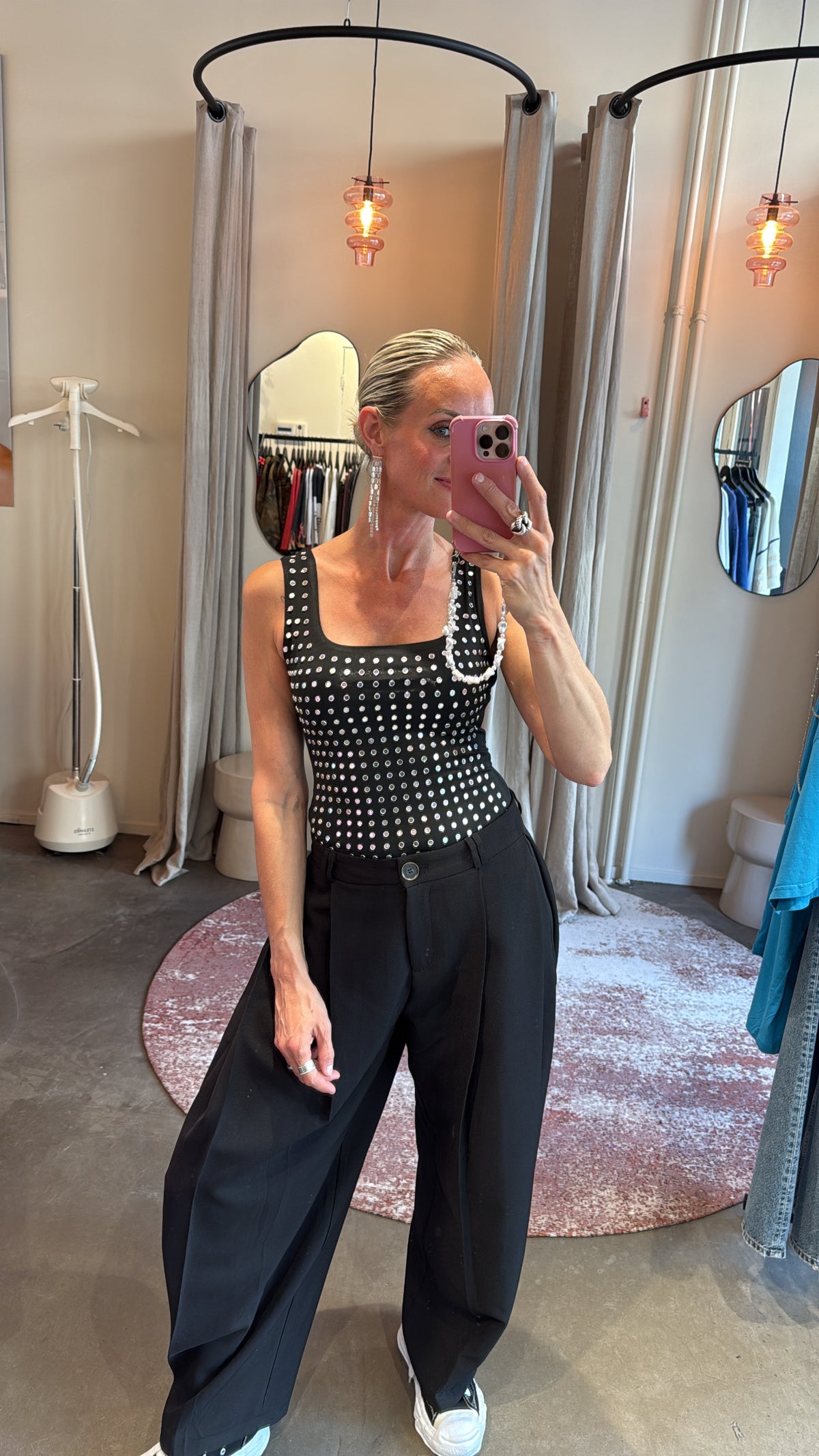 body eyelets black gecombineerd met wijde zwarte broek, close-up vooraanzicht