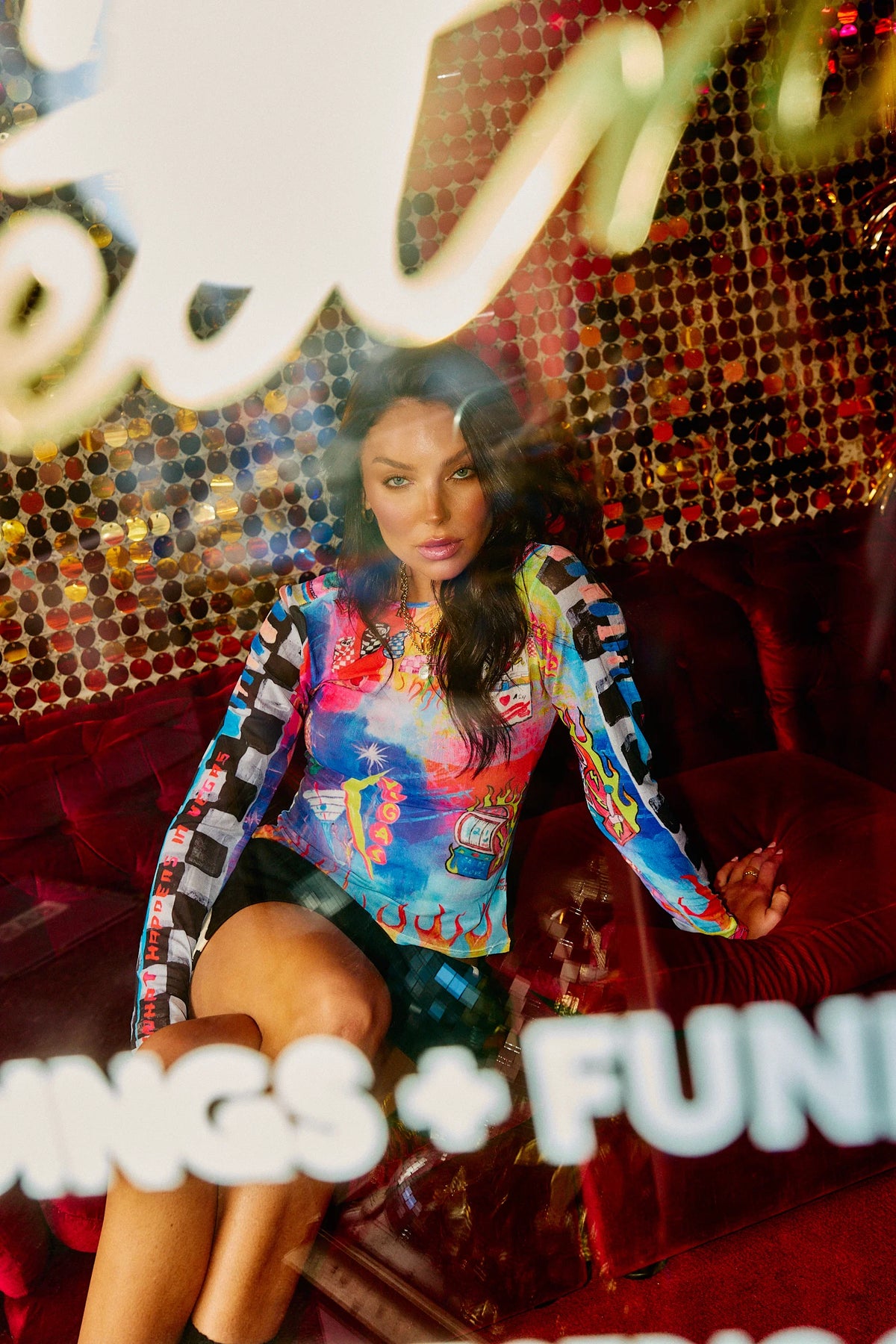 model zittend op bank in vegas mesh top, gecombineerd met rok