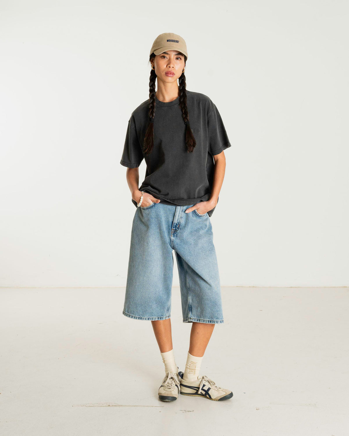 model draagt balo tee washed black van woodbird, vooraanzicht met denim short