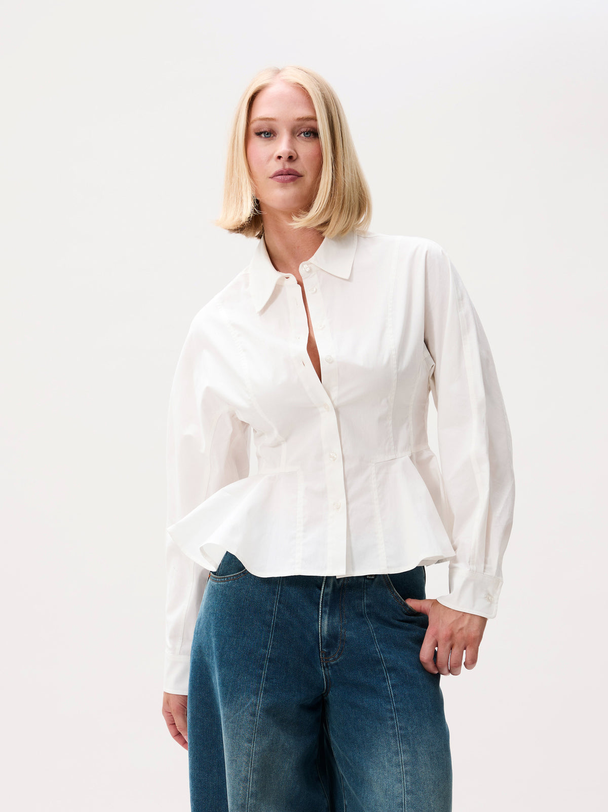 close-up vooraanzicht van model met peplum blouse en knopen in detail