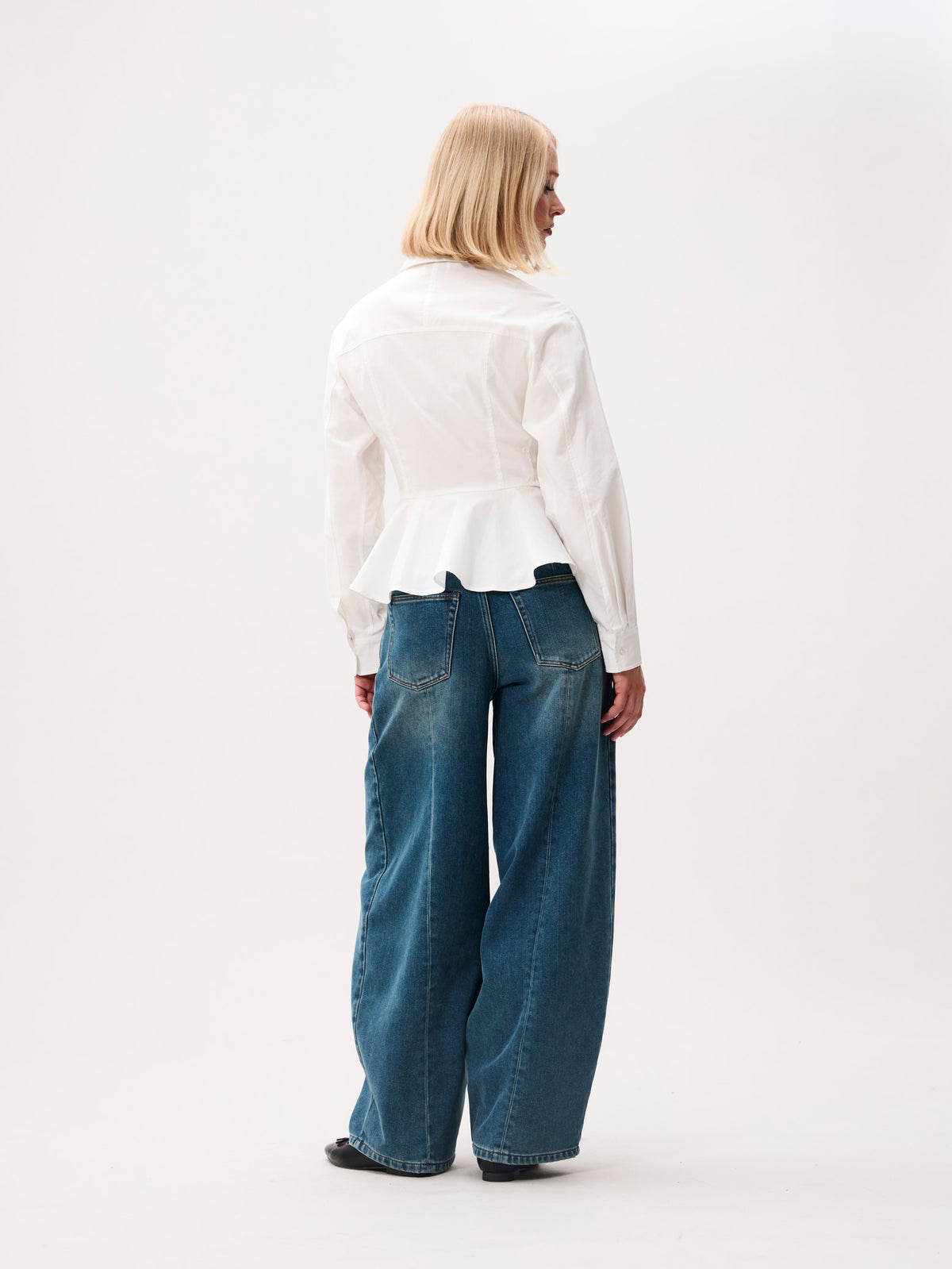 achterkant van de peplum blouse, model gefotografeerd van achteren