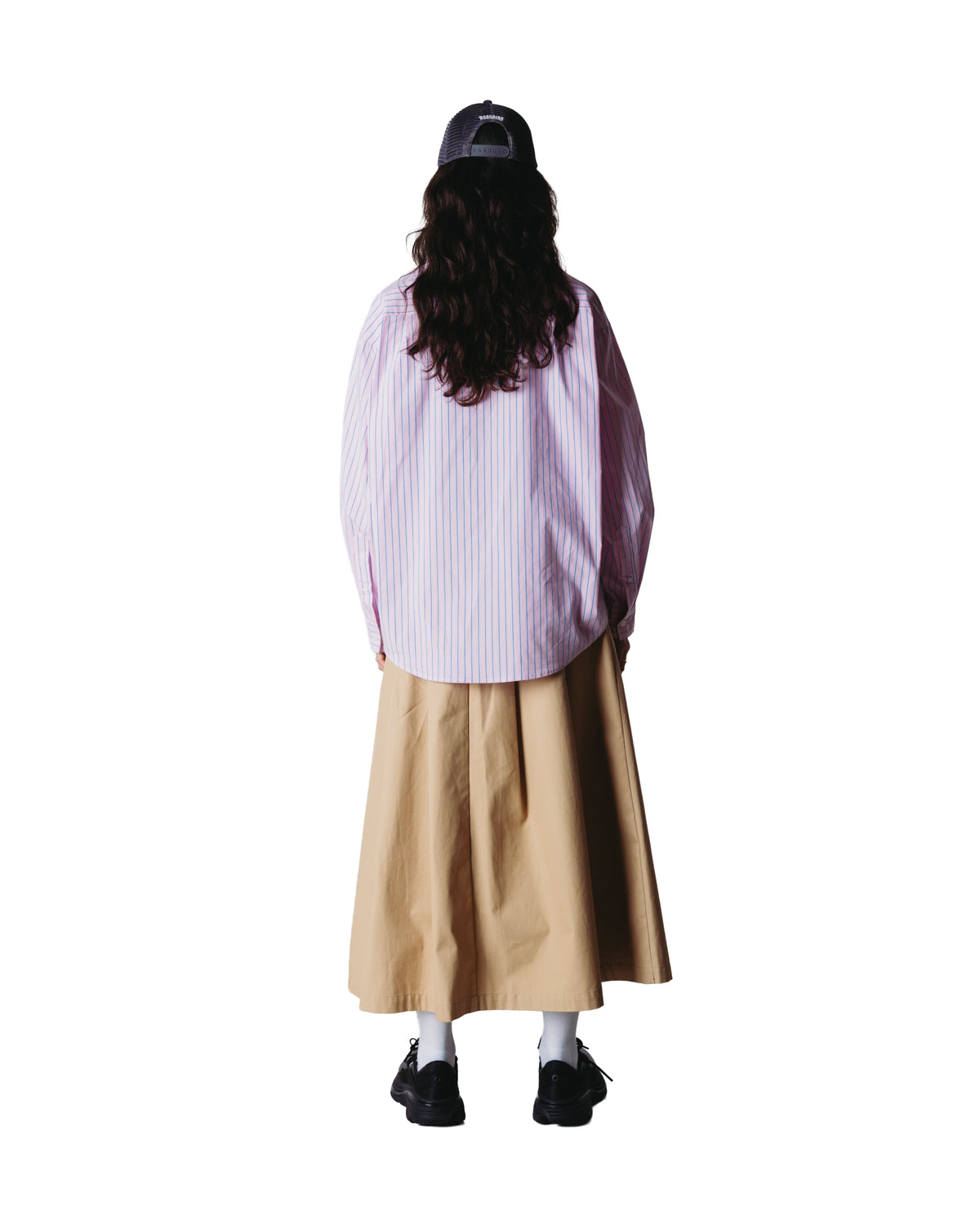 model draagt liva stripe shirt gecombineerd met beige rok, achterkant