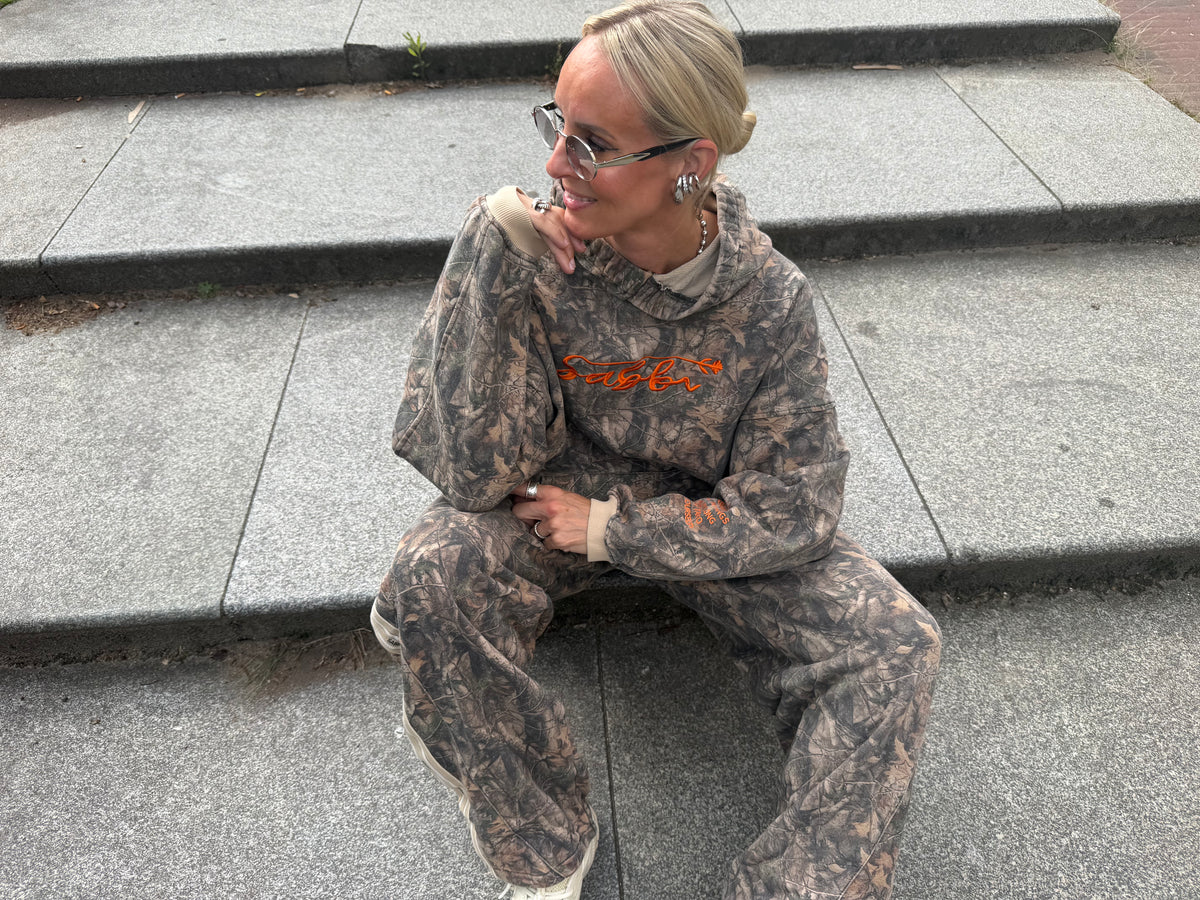 sunnies silver van studio collection, model draagt de zonnebril zittend op een trap