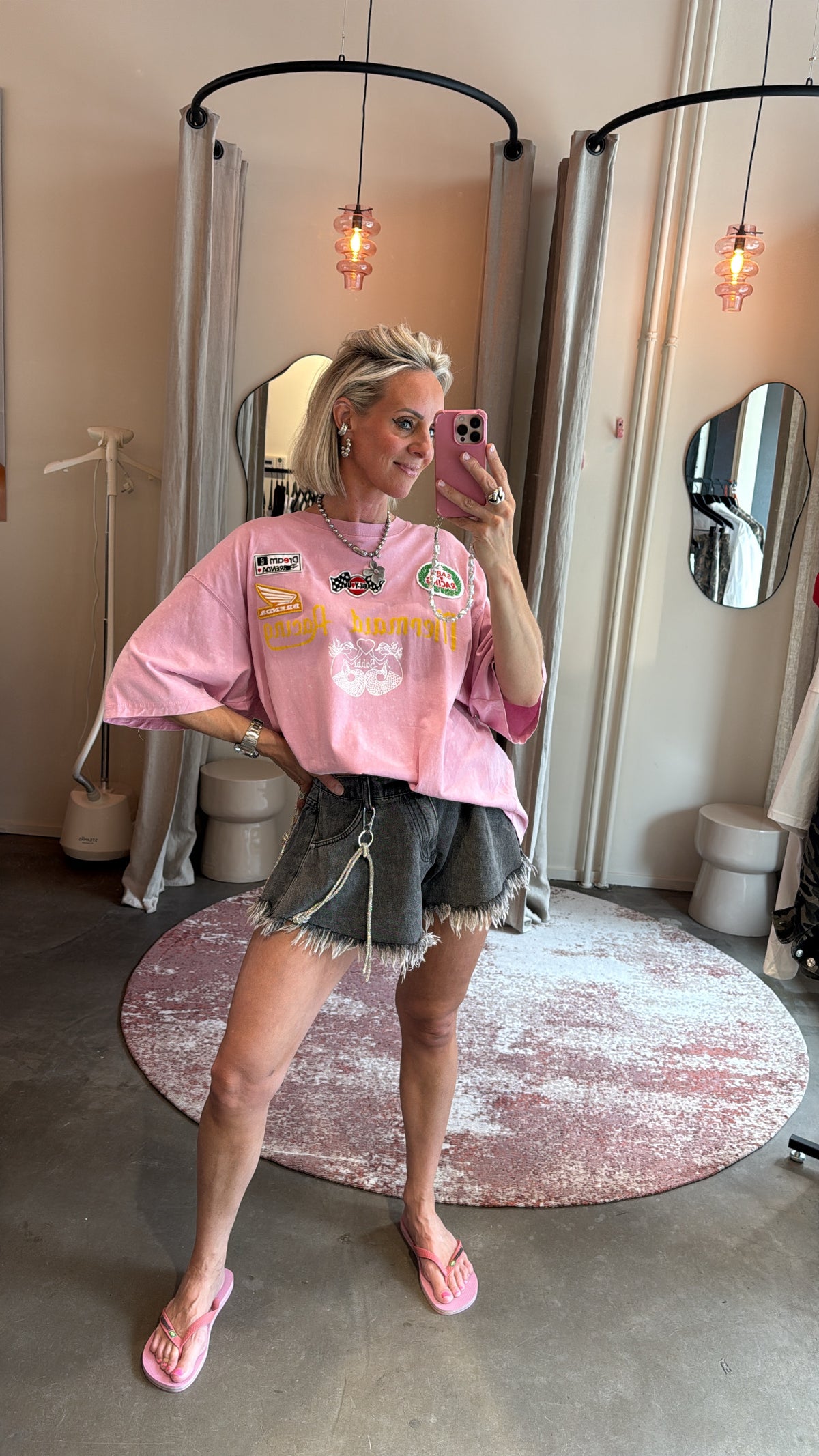model draagt short grey denim van studio collection met gerafelde zoom, gecombineerd met roze top