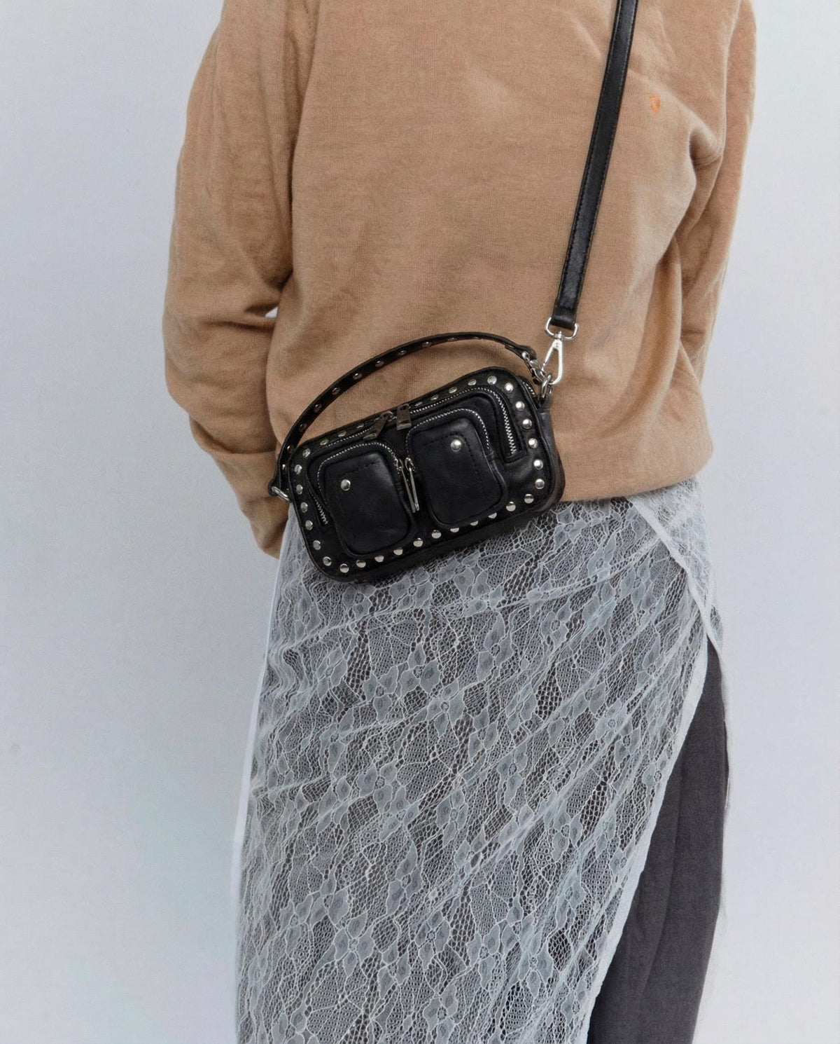 model draagt de helena pure disco black als schoudertas over een rok