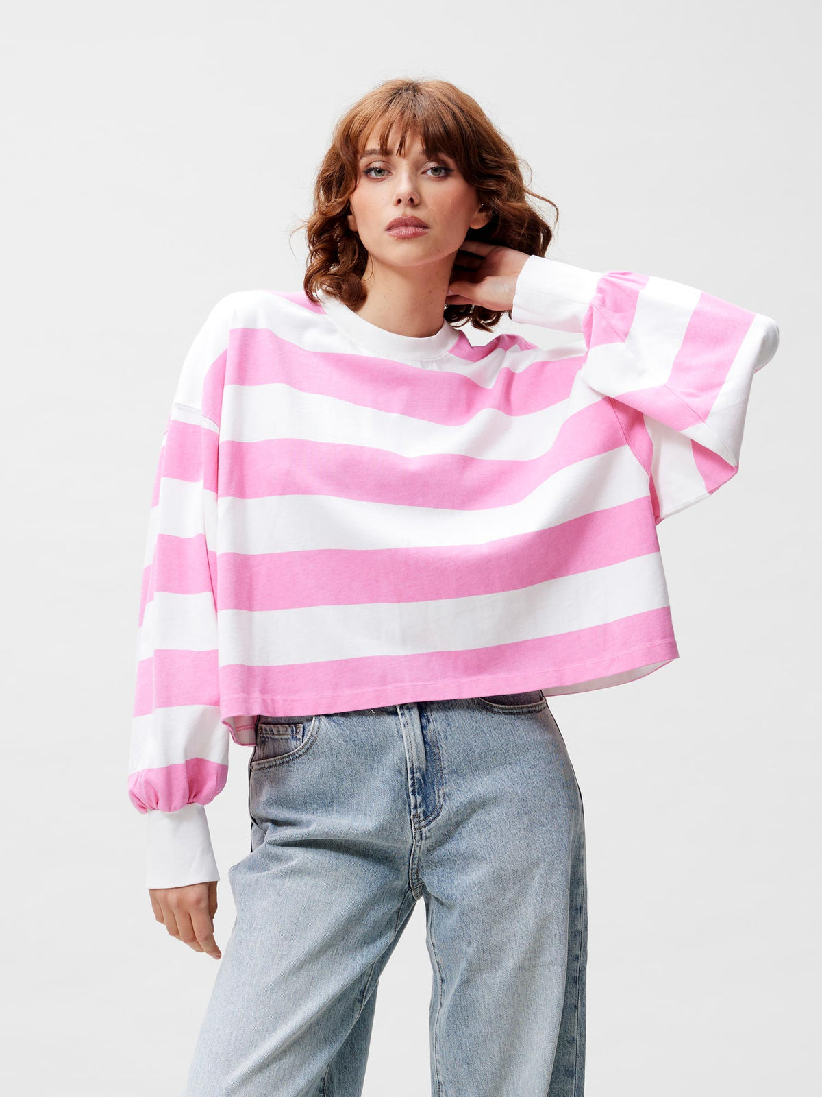 model draagt oversized striped longsleeve van catwalk junkie in roze/wit, close-up vooraanzicht