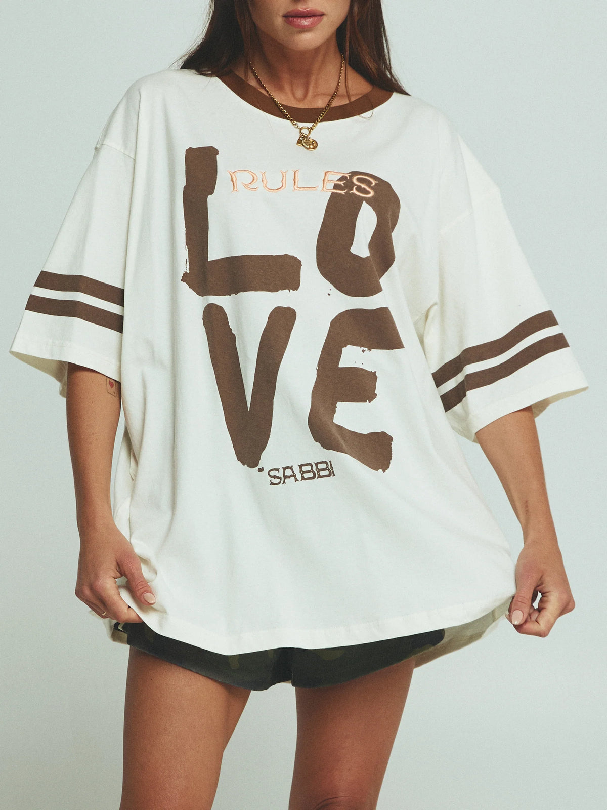 close-up van love-print op oversized tee, gecombineerd met gouden sieraden