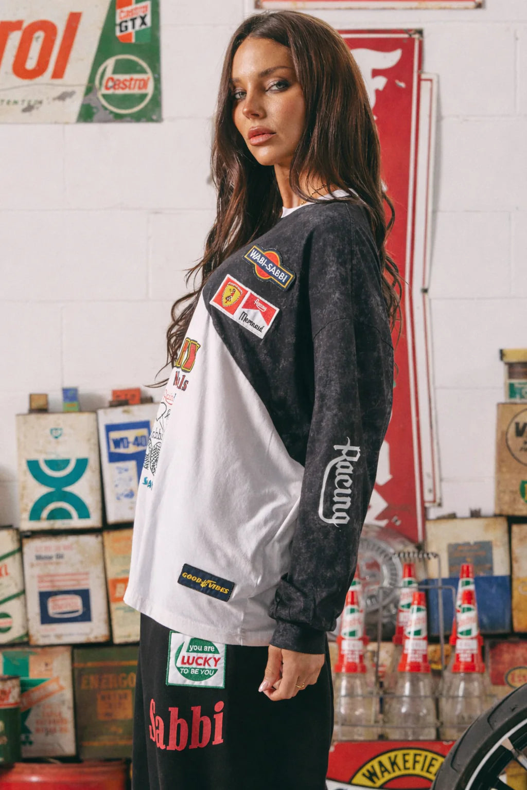 zijaanzicht van model in longsleeve met racing print op mouw en patches op schouder