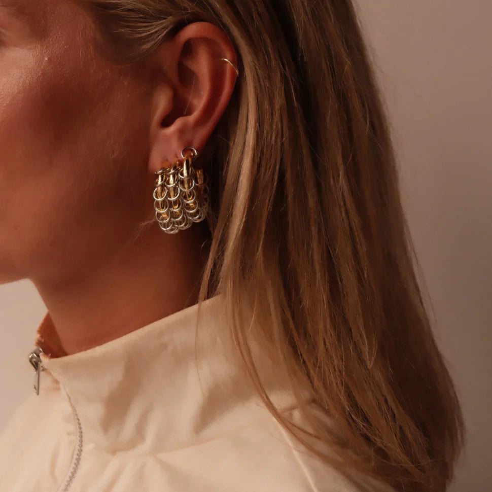 mixed metal earrings van babs the label, model draagt gouden hoops met zilveren ringetjes