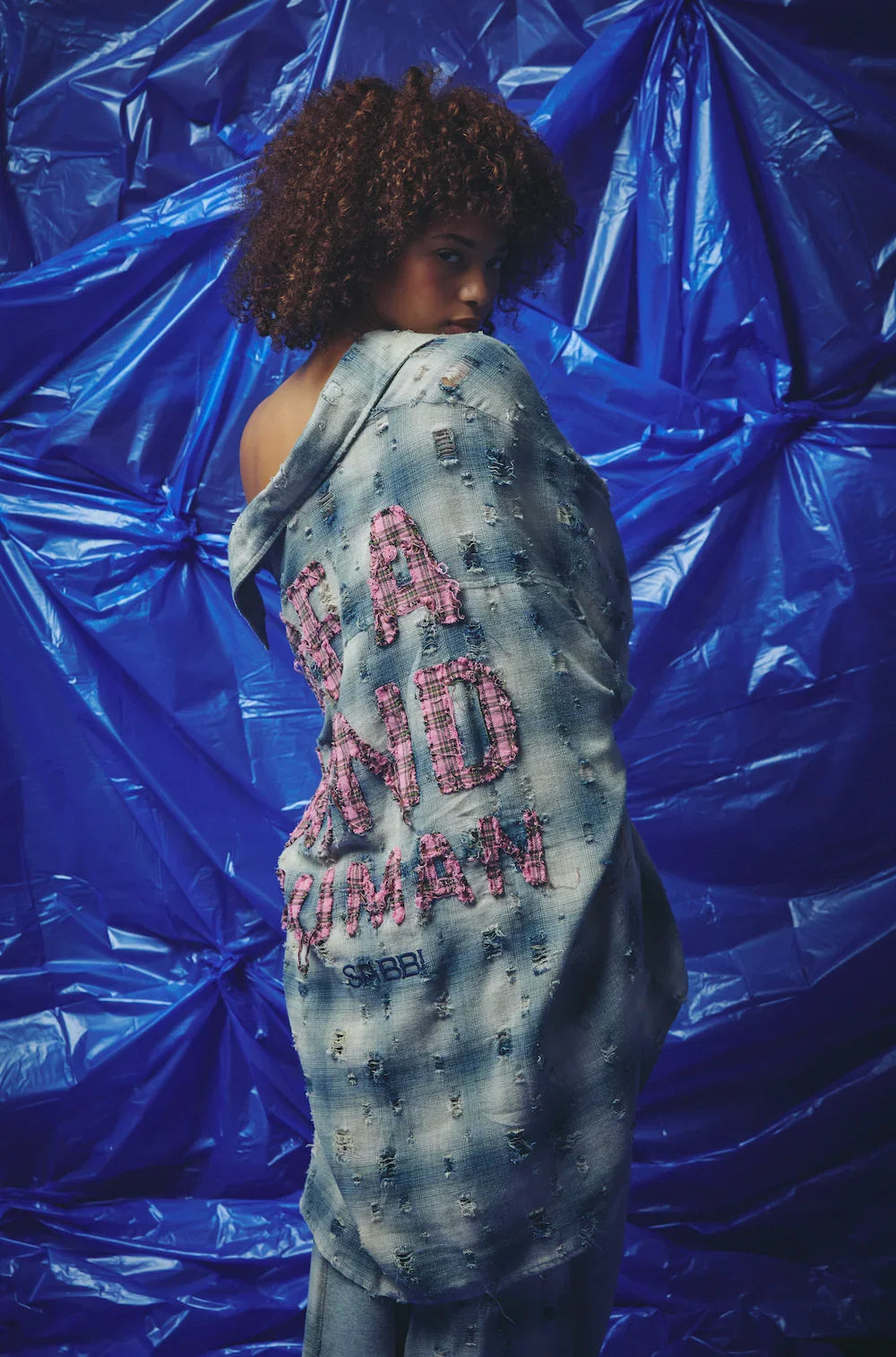 be a kind human overshirt blue van sabbi, model draagt het over de schouder, rugapplicatie in beeld