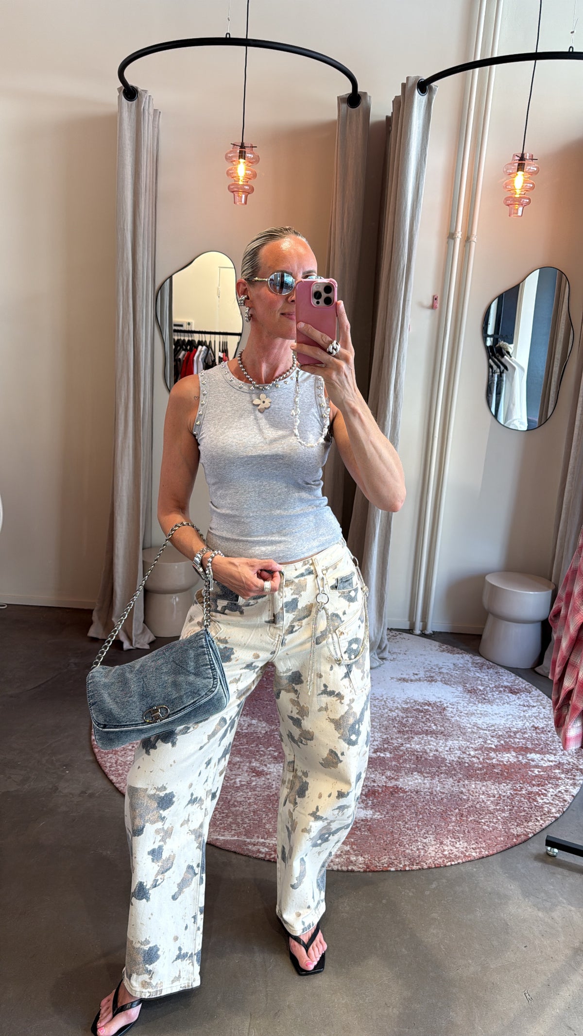 model draagt grijze tanktop met studs gecombineerd met geprinte broek, vooraanzicht