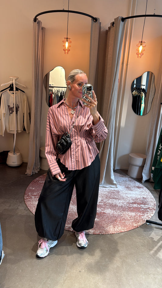 model draagt vegan leather balloon pants black van studio collection met roze blouse, pashokje