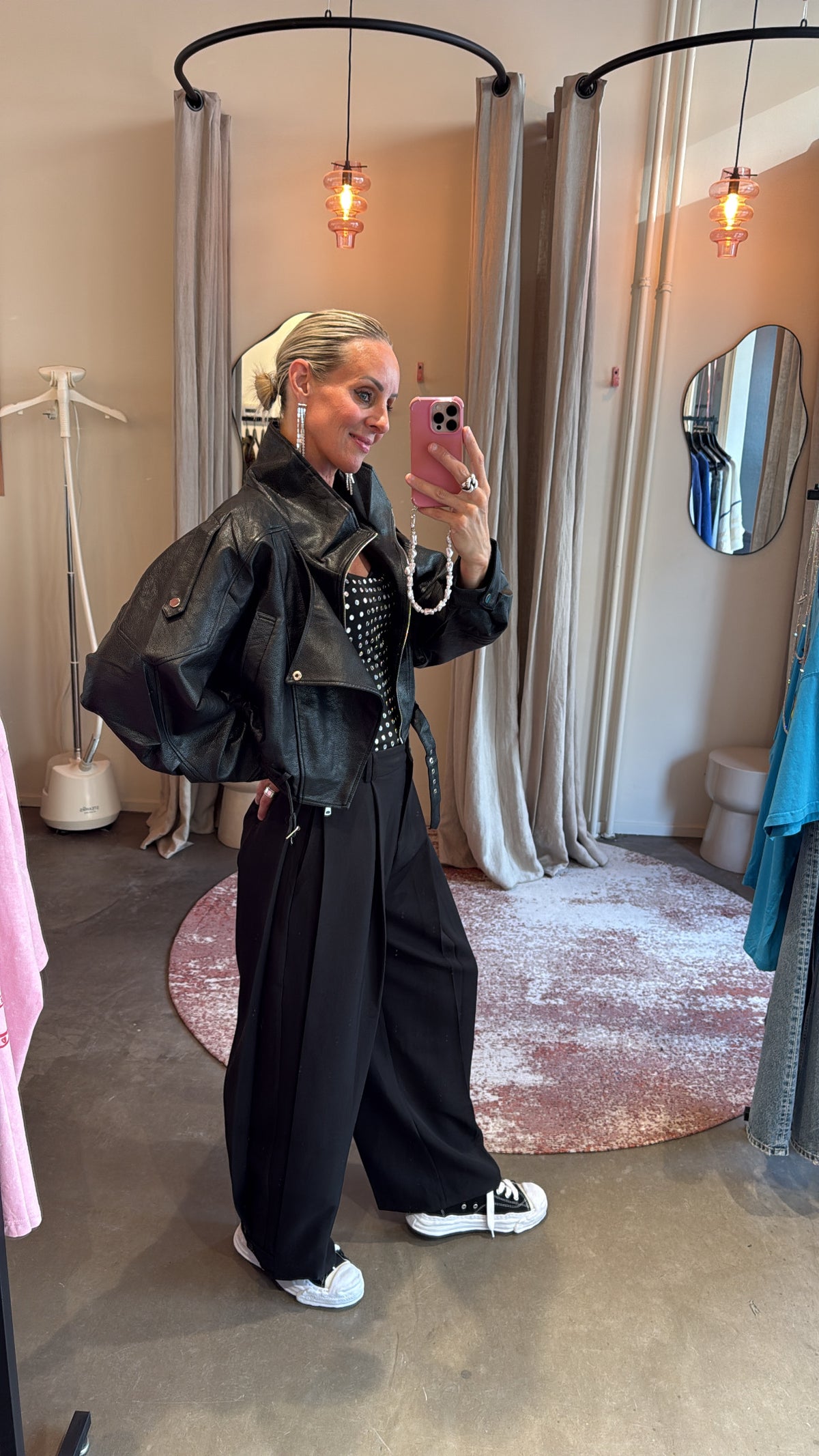 model in bikerjacket black, zijaanzicht met oversized mouwen in pashokje