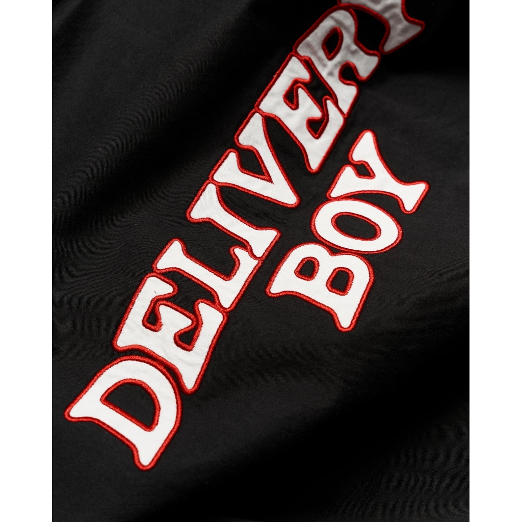 detail van de geborduurde delivery boy tekst op de rug