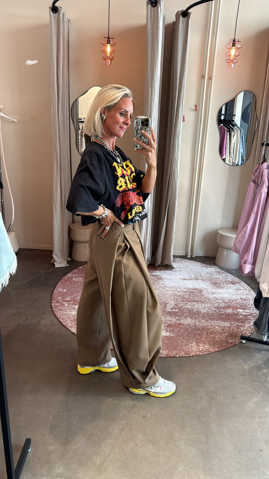 zijaanzicht van baggy pantalon split bruin, split aan de zijkant goed zichtbaar