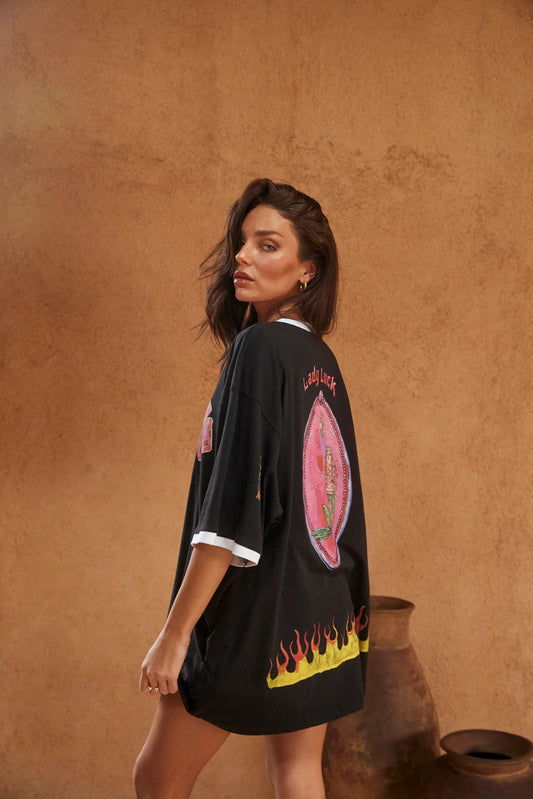 sabbi the lucky mermaid tee, model draagt zwart oversized shirt met lady luck print, achterkant schuin