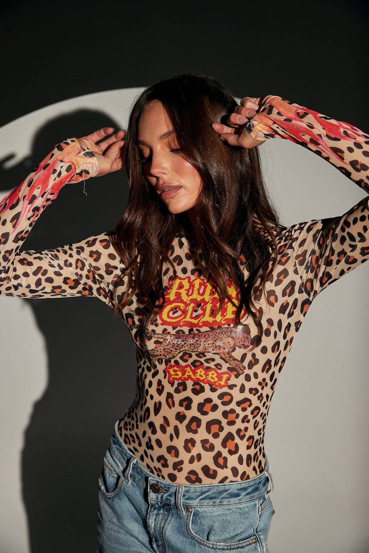 sabbi run club animal mesh longsleeve top, model met handen in haar, close-up print