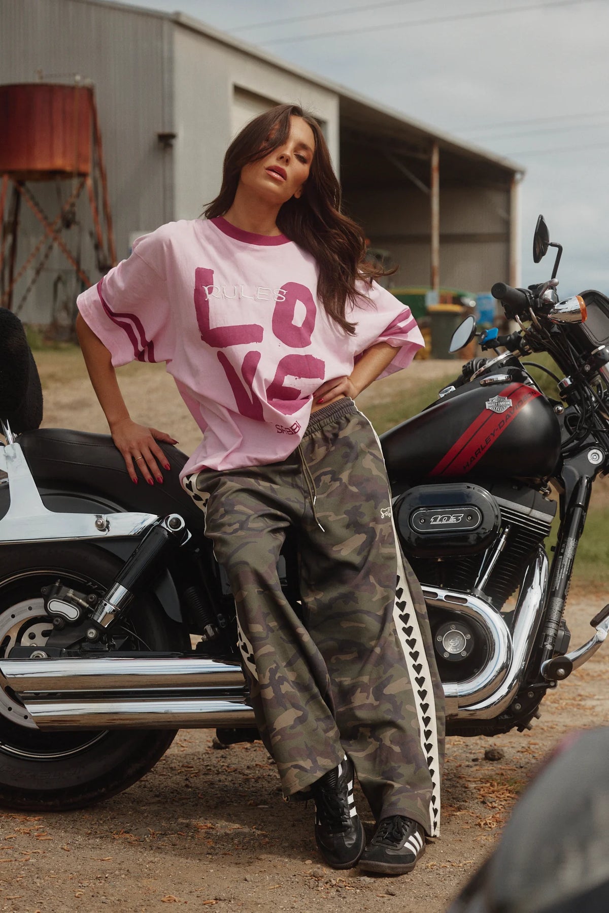 sabbi the raving heart pants camo, model leunt tegen motor met roze oversized shirt