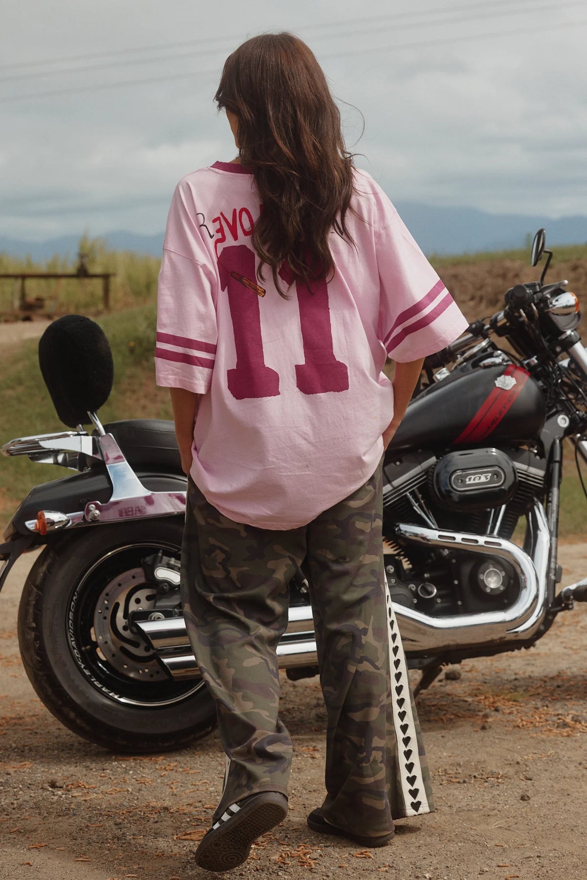 achterkant van de relaxed fit camo broek, model staat bij motor