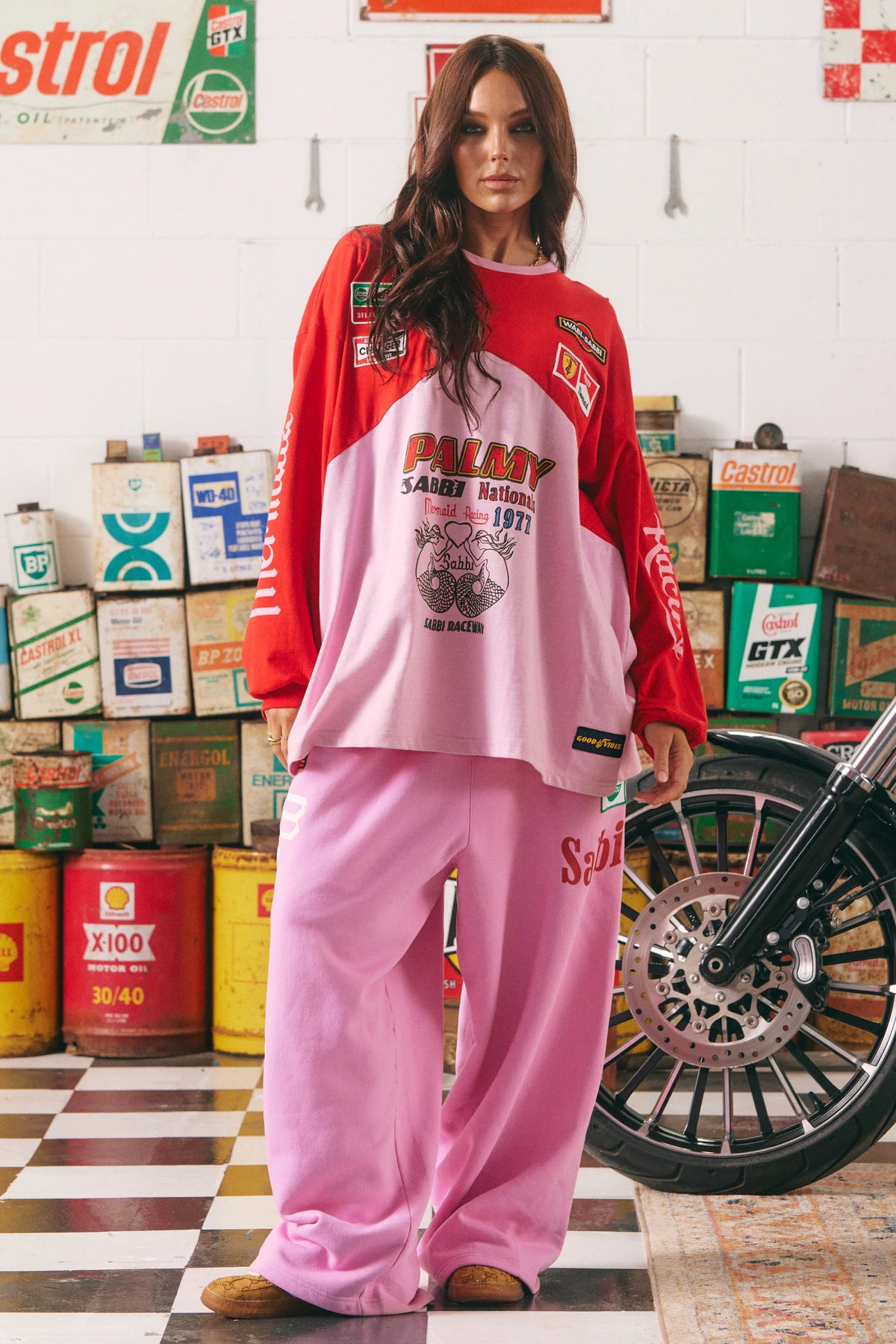 sabbi wide leg sweatpants pink gecombineerd met oversized longsleeve, model staat in garage setting