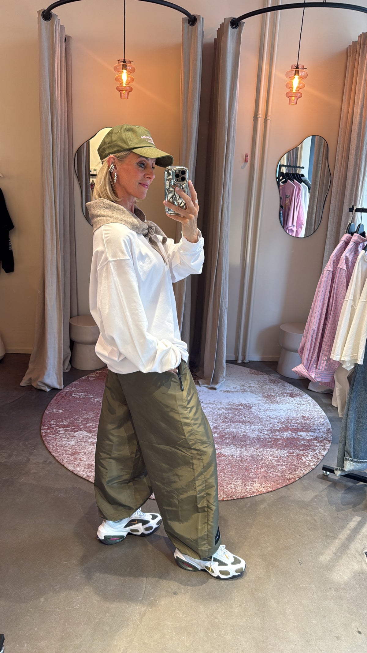 zijaanzicht van model in army harem pant, gestyled met witte blouse en sneakers