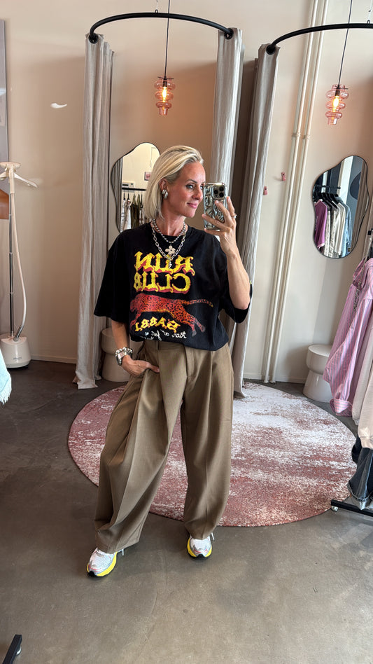 baggy pantalon split bruin van studio collection, model draagt broek met oversized tee in paskamer