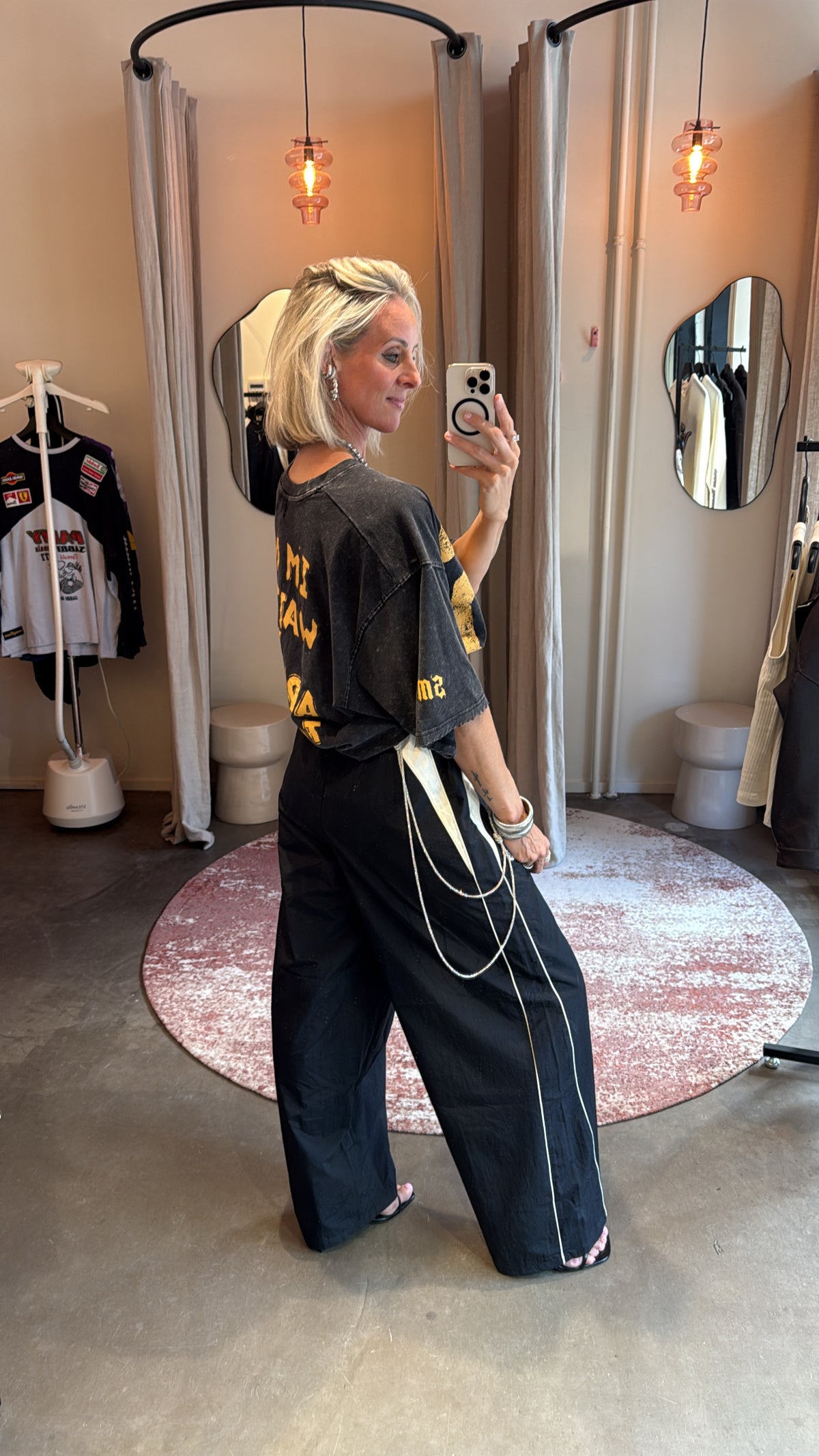 model draagt poke sports pants, achteraanzicht met detail van het koordje en kettinkjes