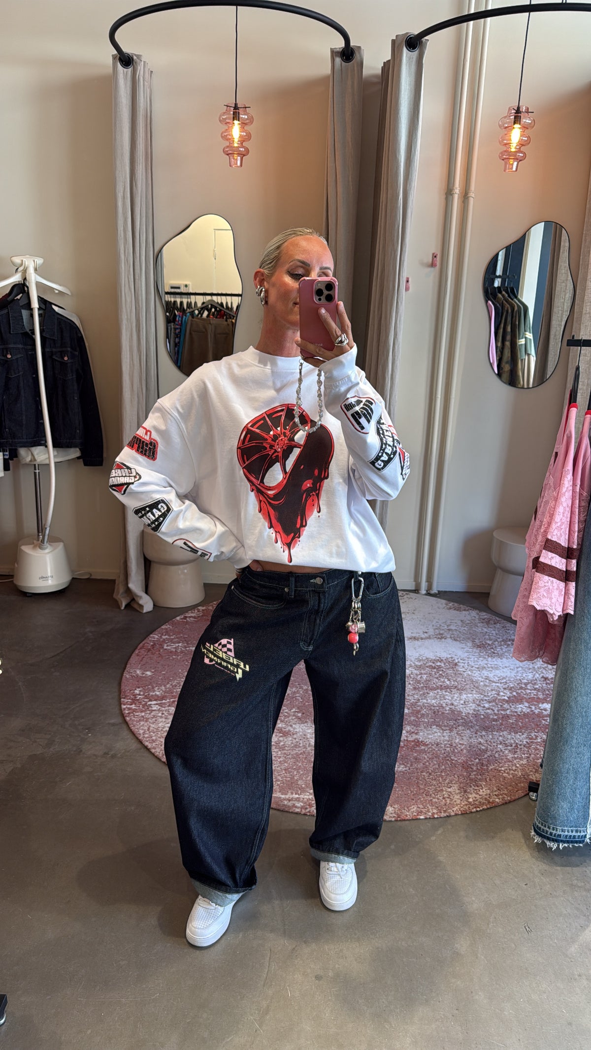 model draagt pitlane denim pants gecombineerd met oversized longsleeve, spiegelselfie in de winkel