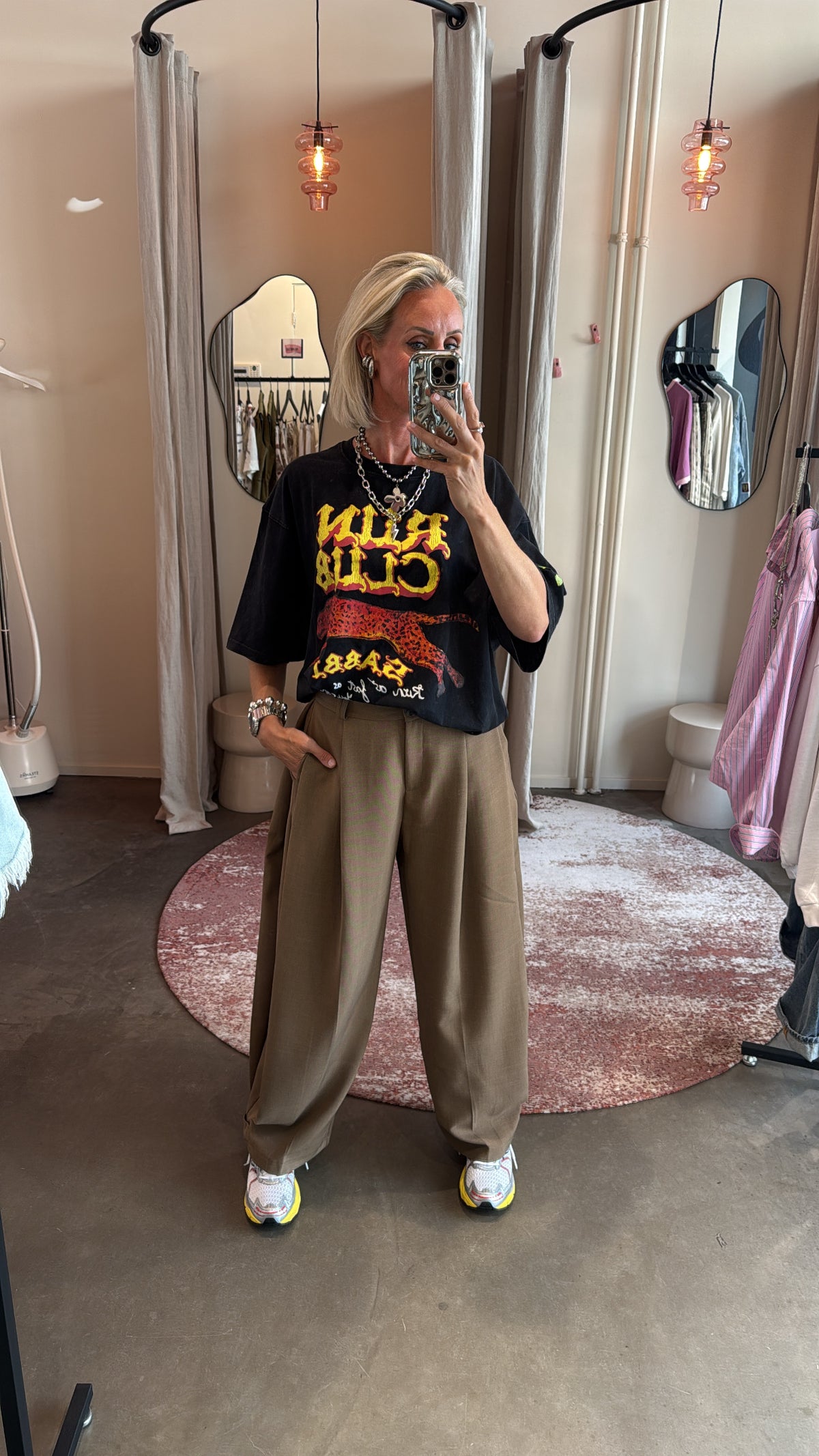 model poseert vooraanzicht in baggy pantalon split bruin, gecombineerd met sneakers