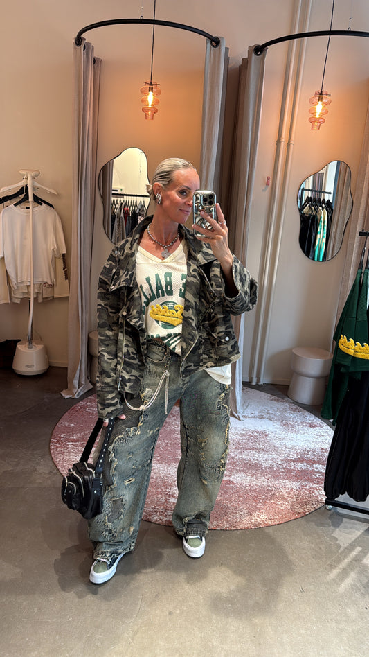oversized camo jacket van studio collection, model draagt jas met graphic tee en baggy jeans, vooraanzicht