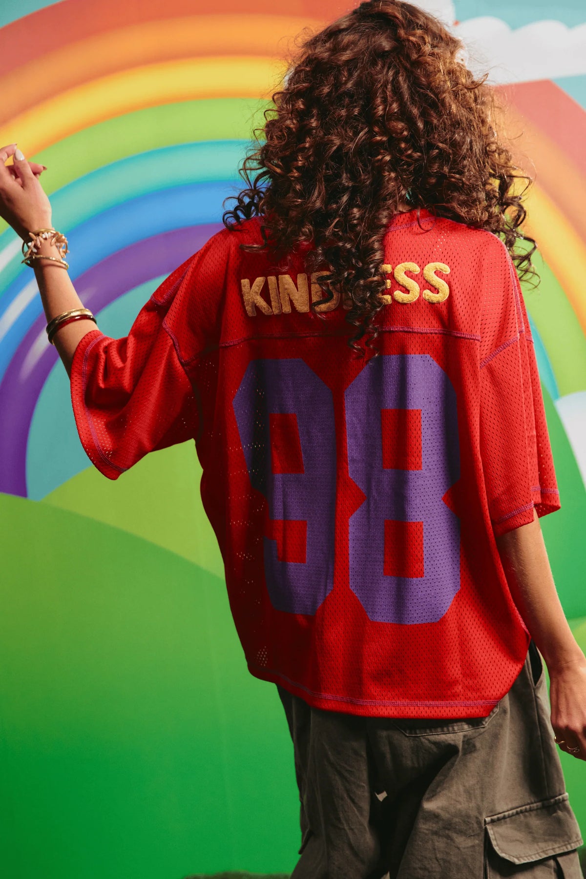 model draagt rode mesh tee, achterkant met print en nummer 98