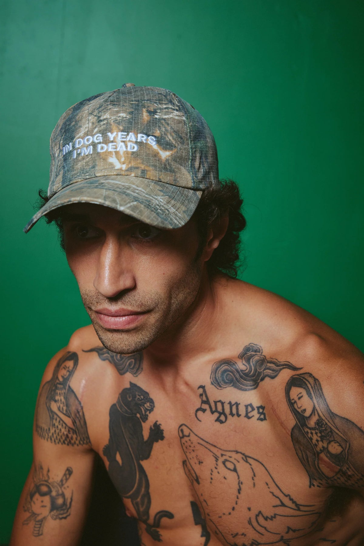 sabbi the dog years cap met camo-finish en geborduurde tekst, model draagt pet naar voren
